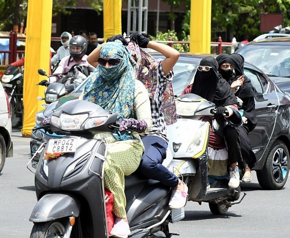 Người dân quấn khăn tránh nắng nóng khi di chuyển trên đường tại Bhopal, Ấn Độ ngày 27/5/2024. (Ảnh: ANI/TTXVN)