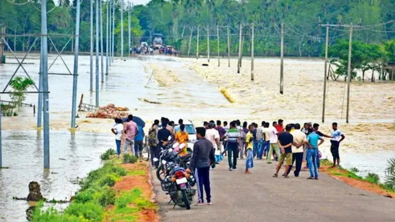 Nước lũ tràn qua một con đường ở quận Hojai, Assam (Ảnh: PTI)