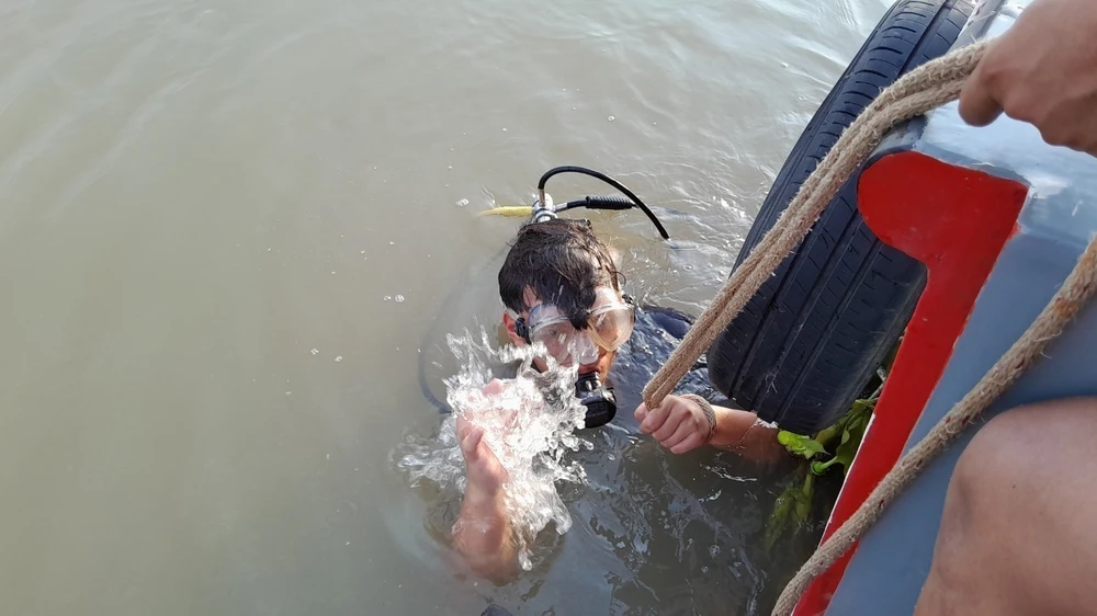 Đưa người nhái của lực lượng PCCC- CHCN lặn tìm các nạn nhân mất tích do đuối nước trên sông Sài Gòn đoạn qua tỉnh Bình Dương. (Ảnh: Dương Chí Tưởng/TTXVN)