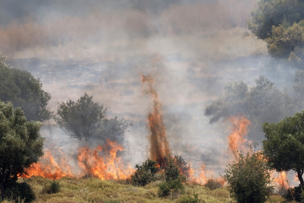 Rocket được bắn từ phía Liban rơi xuống miền Bắc Israel, gây hỏa hoạn ngày 12/6/2024. (Ảnh: AFP/TTXVN)