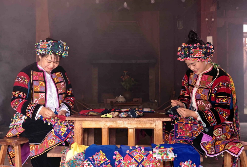 Phụ nữ Lô Lô với bàn tay khéo léo thêu hoa văn trên trang phục truyền thống. (Ảnh: Trần Việt/TTXVN)
