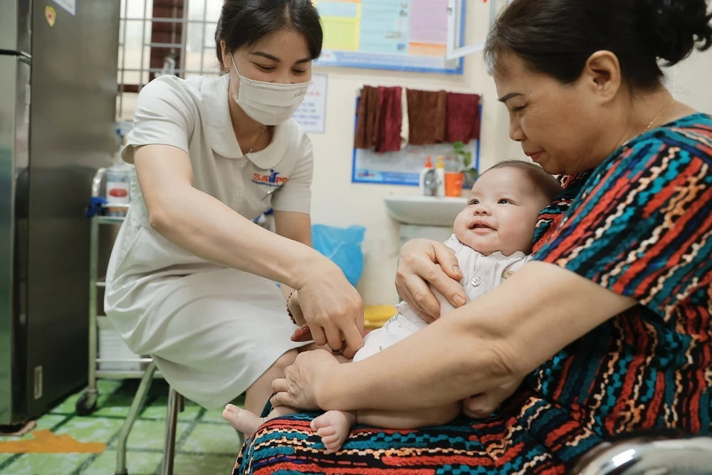 Nhân viên y tế Trung tâm Kiểm soát bệnh tật tỉnh (CDC) Hà Giang tiêm chủng cho trẻ. (Ảnh: Minh Quyết/TTXVN)