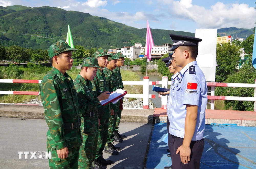 Chỉ huy trưởng tuần tra liên hợp hai bên thông báo, trao đổi thông tin tại vạch phân định cầu hữu nghị cửa khẩu Ma Lù Thàng, Việt Nam và Kim Thủy Hà, Trung Quốc. (Ảnh: TTXVN phát)