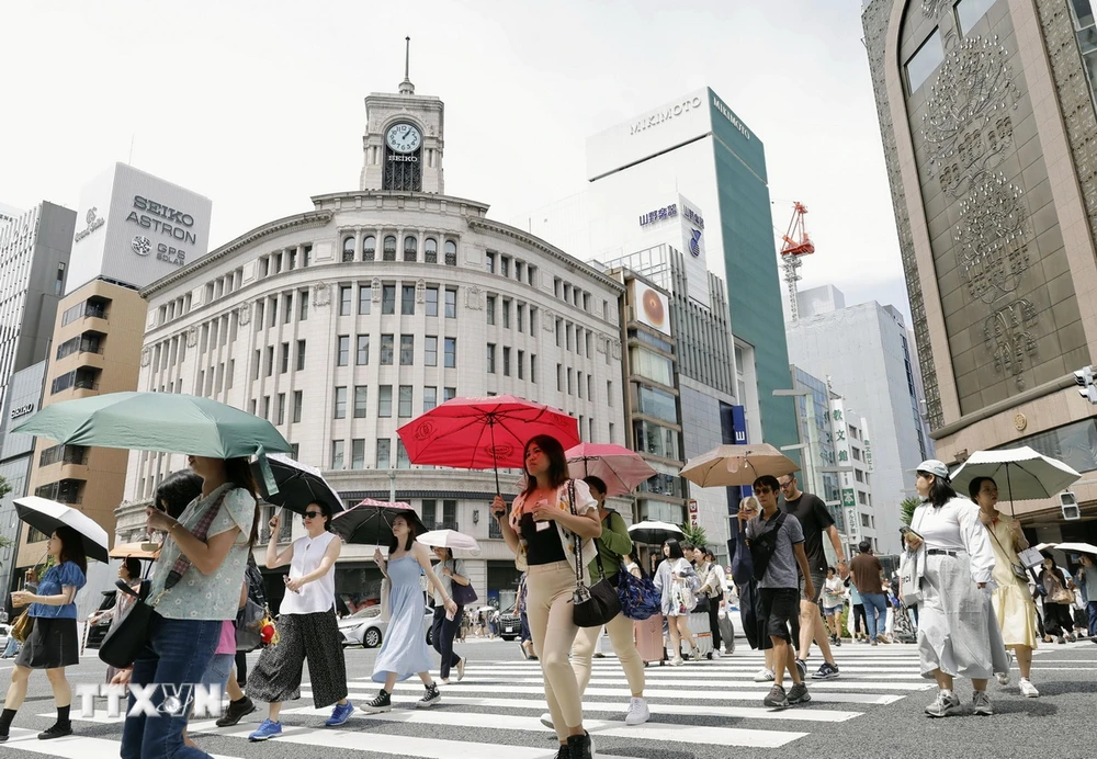 Người dân che ô tránh nắng nóng tại Tokyo, Nhật Bản, ngày 18/7/2024. (Ảnh: Kyodo/TTXVN)