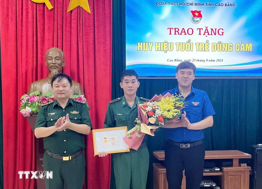 Phó Bí thư Thường trực Tỉnh đoàn, Phó Chủ tịch Hội Liên hiệp thanh niên Việt Nam tỉnh Cao Bằng Hà Ngọc Huy trao tặng Huy hiệu “Tuổi trẻ dũng cảm” cho Binh nhất Lý Văn Vũ. (Ảnh: TTXVN phát)