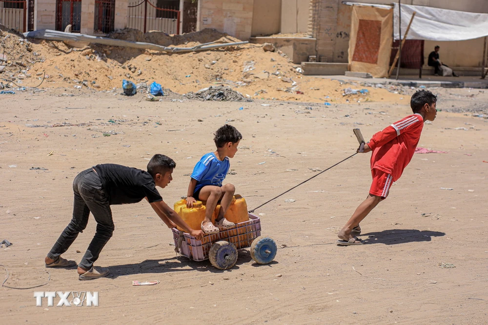 Trẻ em Palestine đi lấy nước sinh hoạt tại Khan Younis, Dải Gaza. (Ảnh: THX/TTXVN)