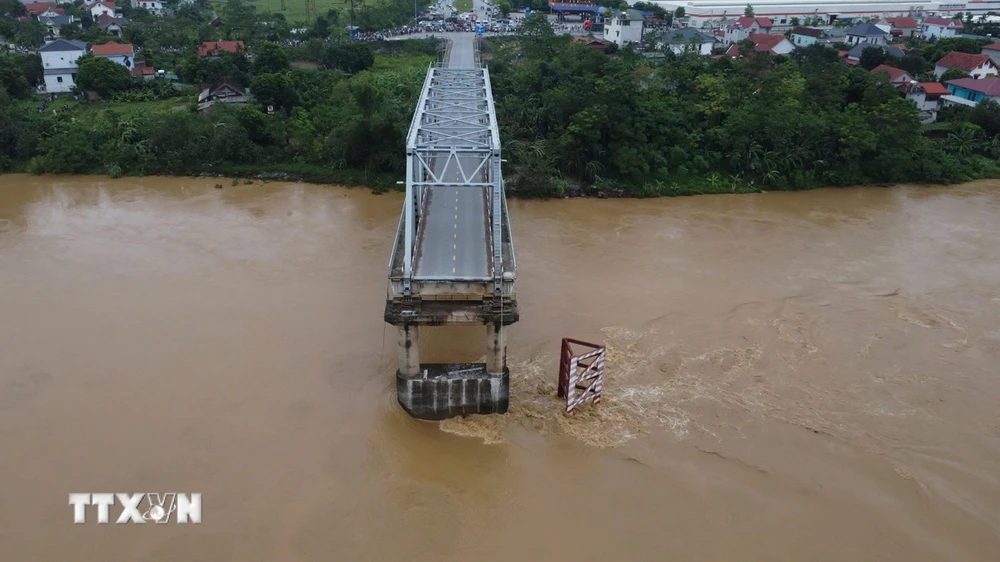 Cầu Phong Châu (Phú Thọ) bị sập, sáng 9/9. Một trụ và hai nhịp của cây cầu đã bị nước lũ cuốn. (Ảnh: Tạ Toàn/TTXVN)