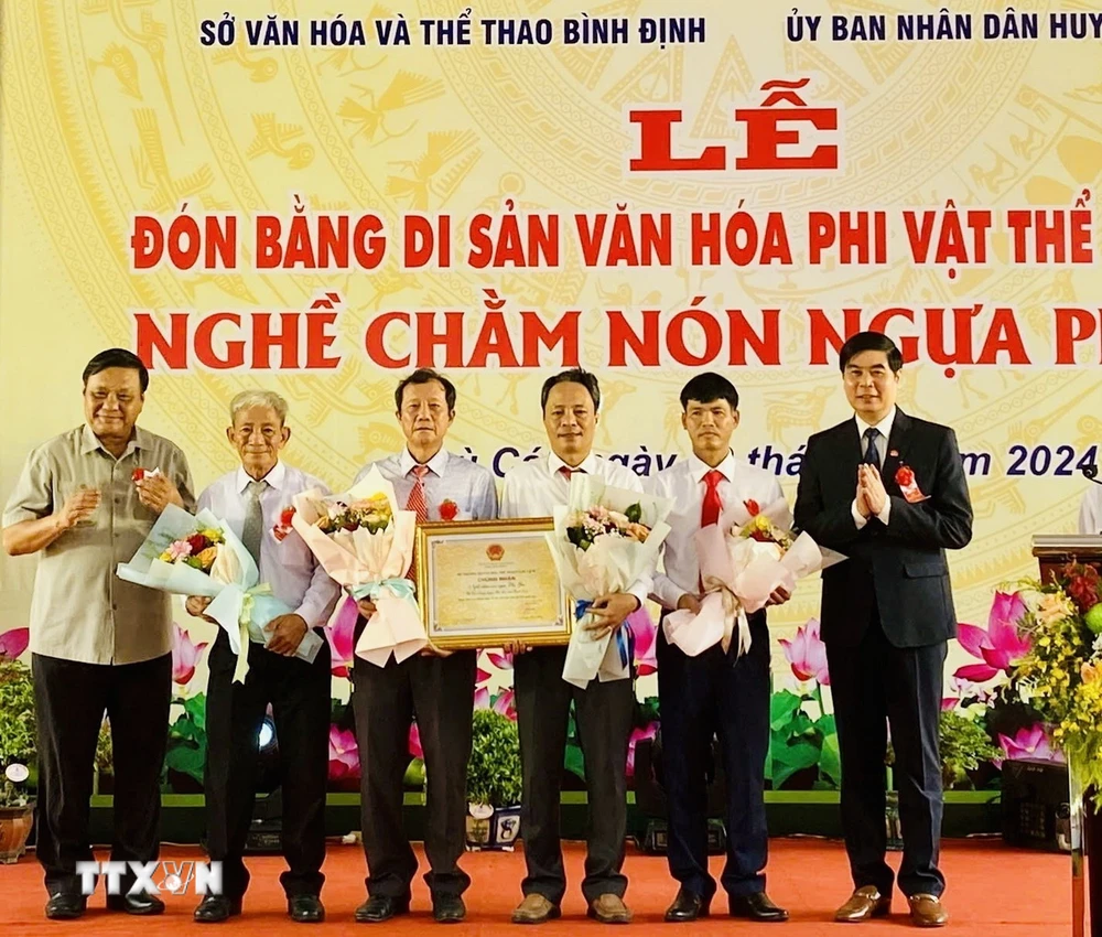 Trao Bằng chứng nhận di sản văn hóa phi vật thể Quốc gia "Nghề chằm nón ngựa Phú Gia" cho Đảng bộ, chính quyền huyện Phù Cát. (Ảnh: TTXVN phát)