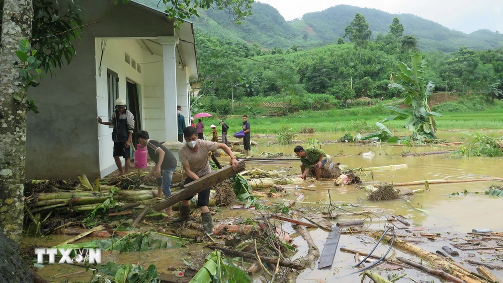 Người dân thôn Làng Nủ nỗ lực tìm người thân bị nạn sau lũ dữ. (Ảnh: Hồng Ninh -TTXVN)