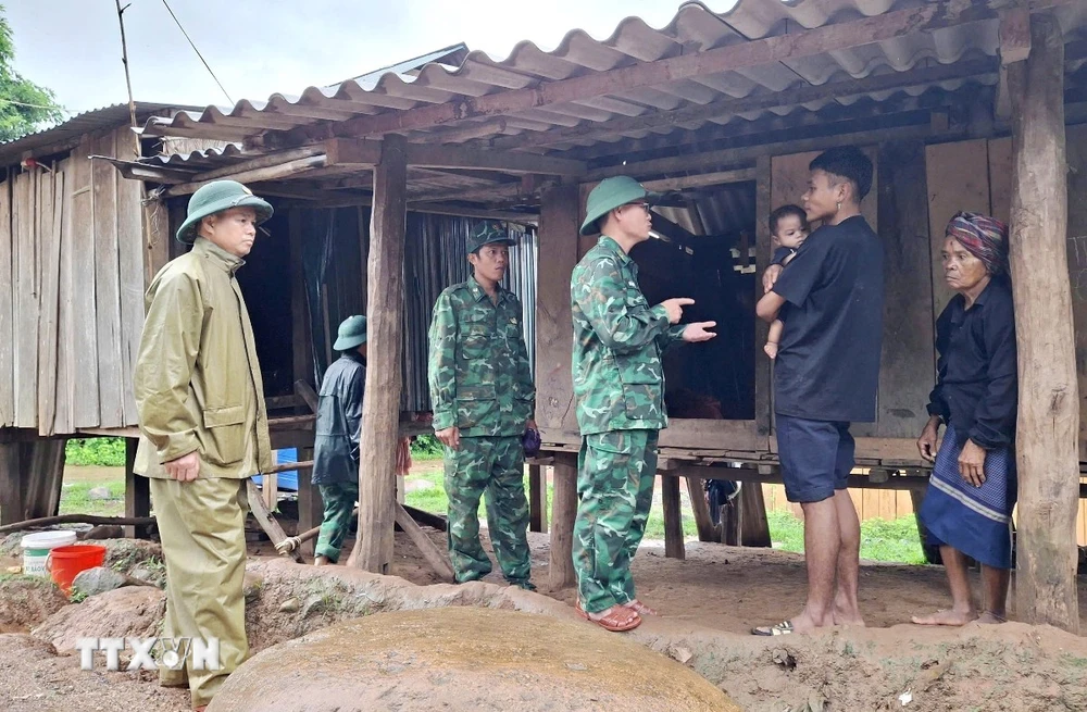 Cán bộ Đồn Biên phòng Cửa khẩu quốc tế Cha Lo (Bộ đội Biên phòng Quảng Bình) phối hợp với địa phương tuyên truyền người dân chủ động thực hiện các biện pháp ứng phó thiên tai. (Ảnh: TTXVN phát)