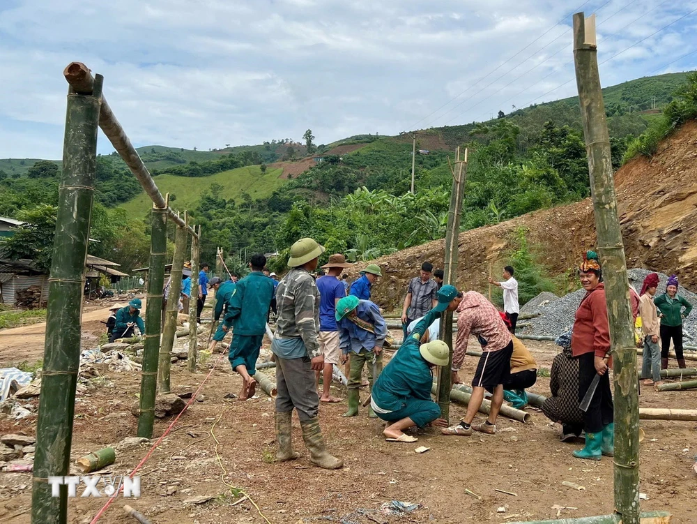 Các lực lượng hỗ trợ người dân bản Nà Mện (xã Nậm Ty, huyện Sông Mã, tỉnh Sơn La) làm lán ở tạm. (Ảnh: TTXVN phát)