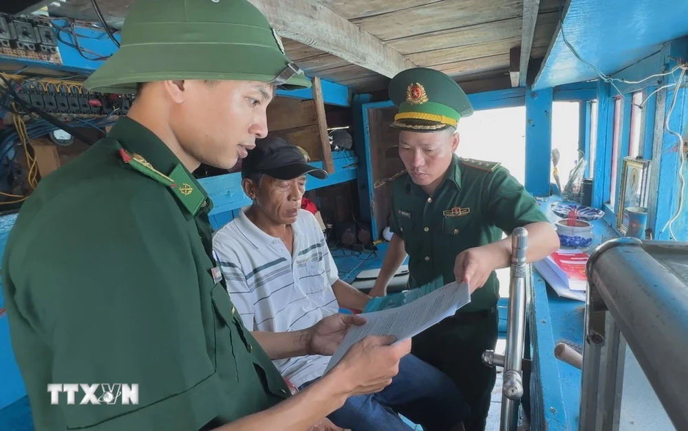 Lực lượng chức năng tuyên truyền, hướng dẫn ngư dân thực hiện các hồ sơ, thủ tục đăng ký, đăng kiểm. (Ảnh: TTXVN phát)