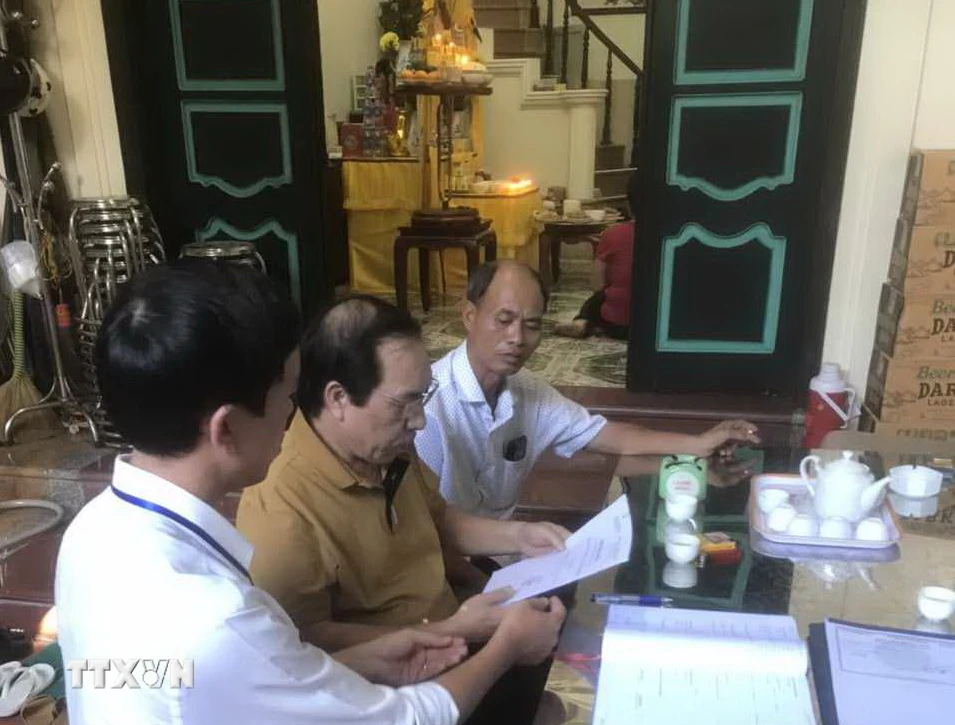 Ủy ban Nhân dân phường Nhật Tân (Tây Hồ), trao Giấy khai tử tại nhà cho đại diện gia đình có người mất. (Ảnh Mạnh Khánh/TTXVN) 