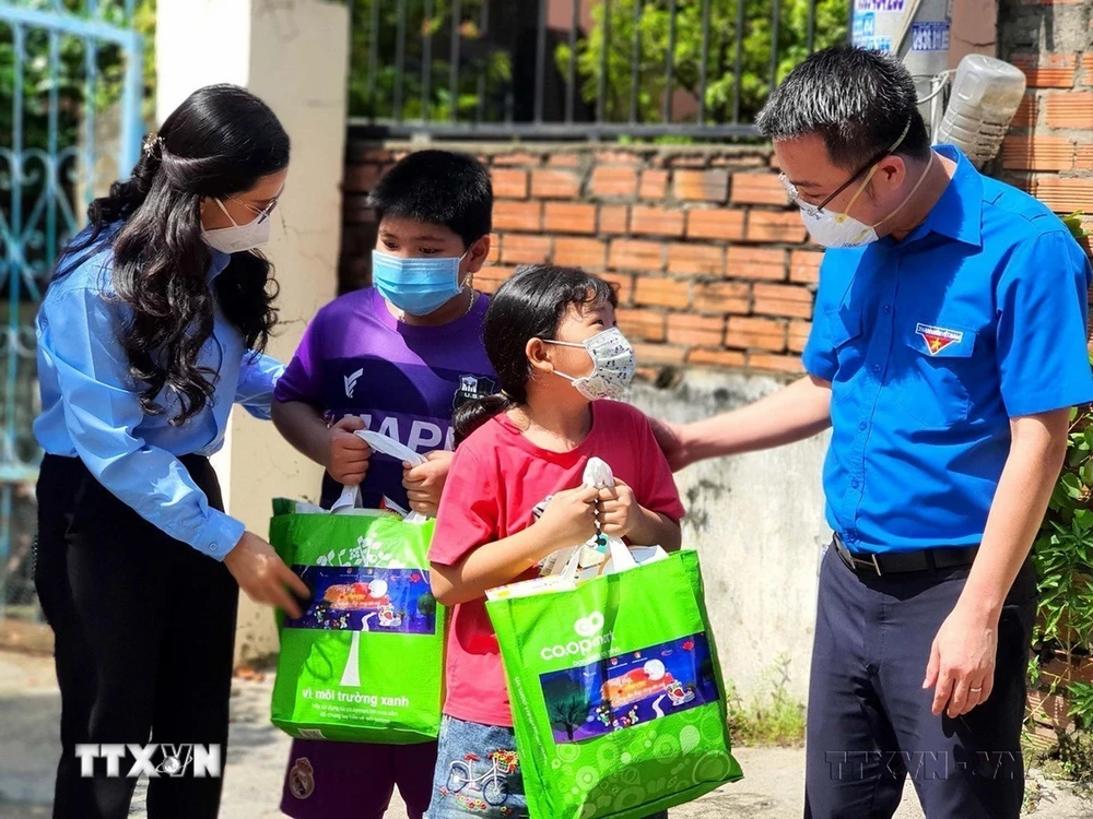 Đoàn viên, thanh niên Thành phố Hồ Chí Minh thăm hỏi, tặng quà cho con công nhân có hoàn cảnh khó khăn, người lao động tại các khu nhà trọ. (Ảnh: Thanh Vũ/TTXVN) 