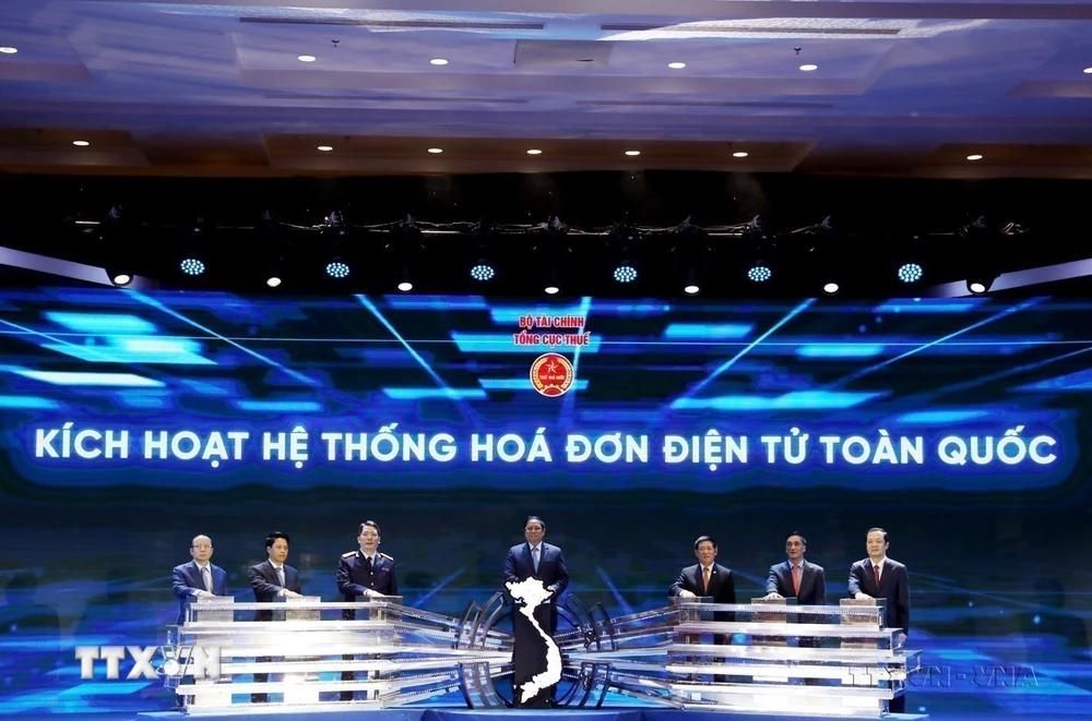 Thủ tướng Phạm Minh Chính và các đại biểu ấn nút kích hoạt Hệ thống Hóa đơn Điện tử Toàn quốc. (Ảnh: Phạm Hậu/TTXVN)
