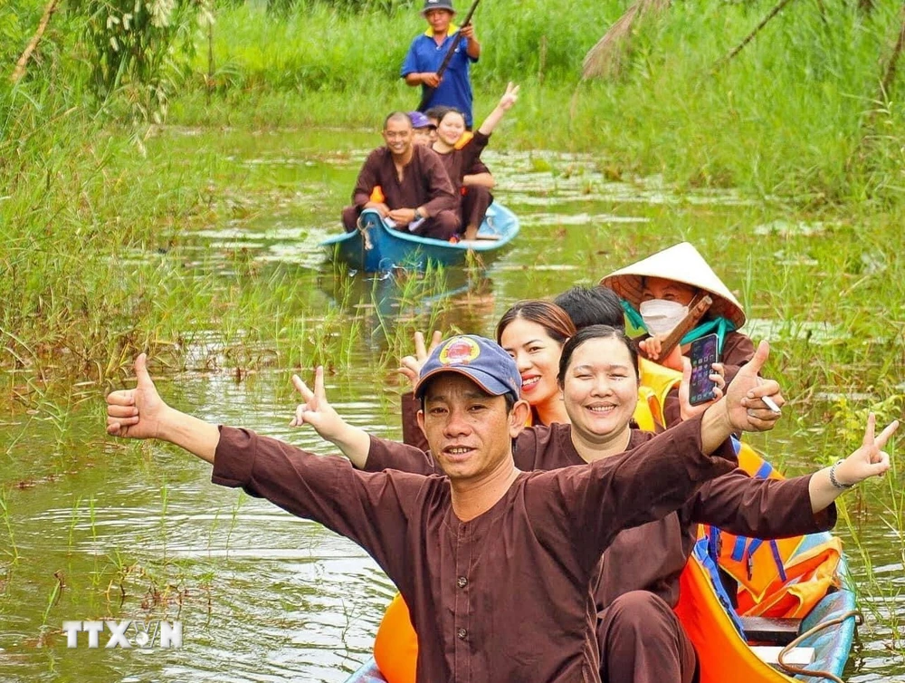 Du khách thích thú với hình thức đi xuyên rừng bằng xuồng ba lá tại điểm du lịch sinh thái ở vùng rừng U Minh hạ. (Ảnh: Huỳnh Anh/TTXVN)