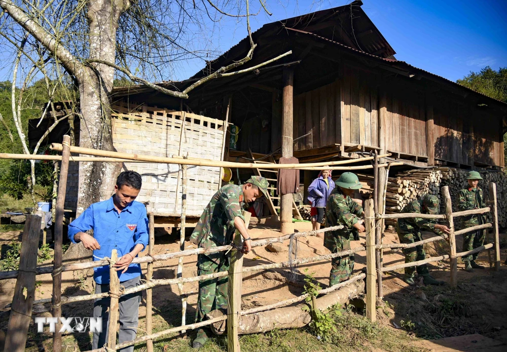 Chiến sỹ Trung đoàn 741, Bộ Chỉ huy Quân sự tỉnh Điện Biên cùng Đoàn Thanh niên xã Nậm Vì làm lại hàng rào cho người dân bản Nậm Vì. (Ảnh: Xuân Tư/TTXVN)