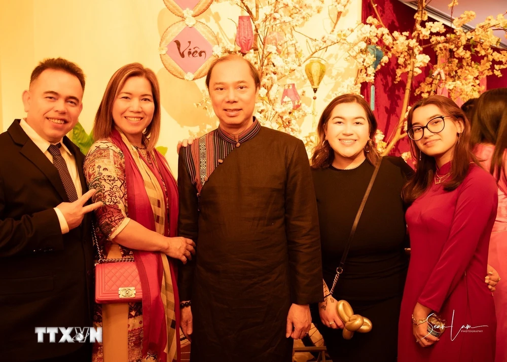 Đại sứ Nguyễn Quốc Dũng chụp ảnh cùng một gia đình Việt kiều vùng DMV. (Ảnh: Kiều Trang/TTXVN)