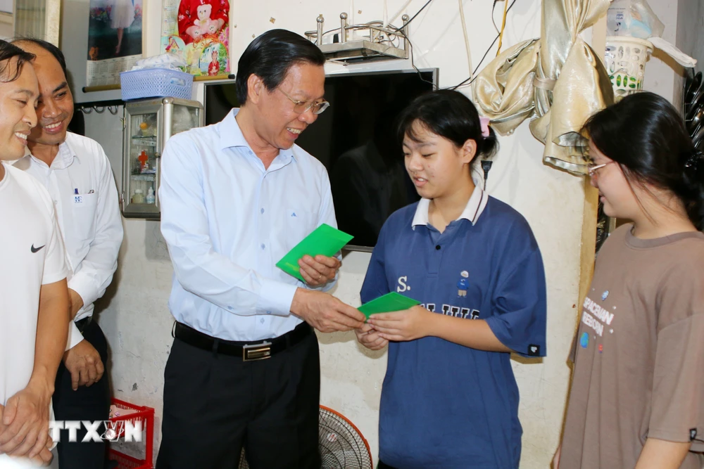 Chủ tịch Ủy ban Nhân dân Thành phố Hồ Chí Minh Phan Văn Mãi lì xì Tết cho con em công nhân, người lao động tại nhà lưu trú công nhân Hiệp Phước. (Ảnh: Thanh Vũ/ TTXVN)