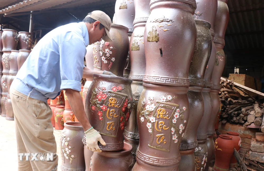 Người làng nghề hối hả cho ra những mẻ gốm cho thị trường Tết. (Ảnh: Thanh Thương/TTXVN)