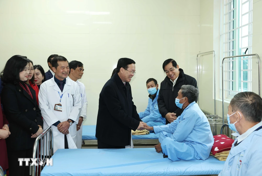 Chủ tịch nước Võ Văn Thưởng thăm hỏi bệnh nhân tại Trung tâm Y tế huyện Thanh Liêm. (Ảnh: Thống Nhất/TTXVN)