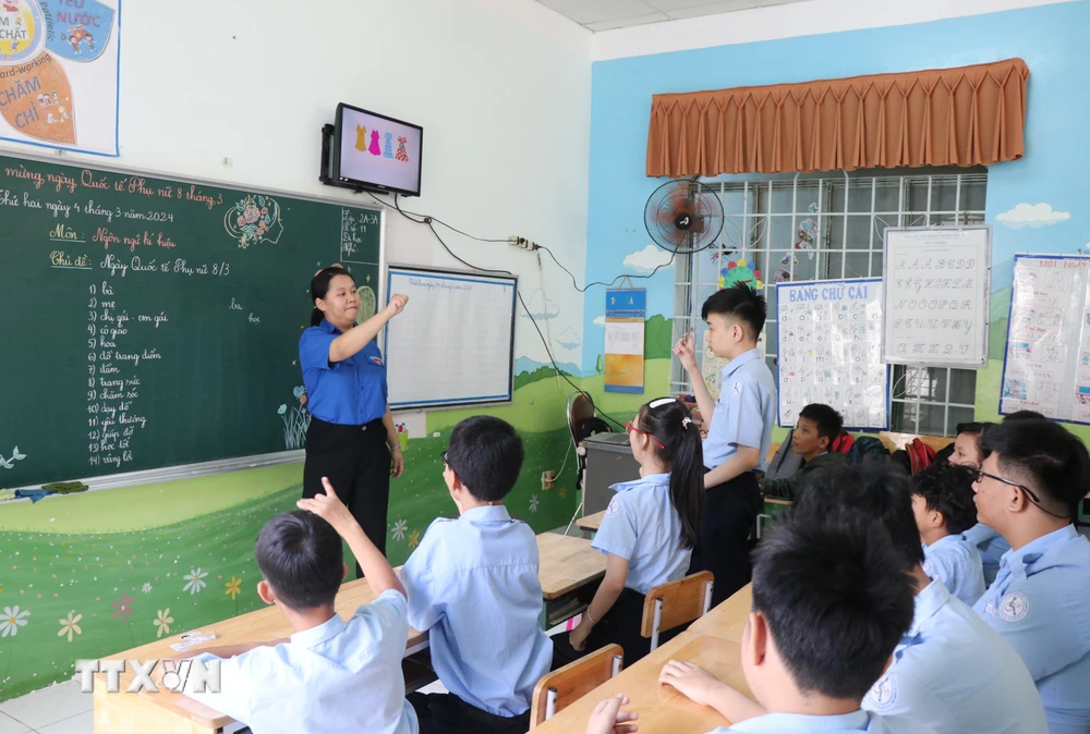 Một giờ học của học sinh khuyết tật khiếm thính khối 2-3, cô giáo hướng dẫn học sinh diễn đạt từ ngữ bằng ngôn ngữ ký hiệu. (Ảnh: Phan Sáu/TTXVN)