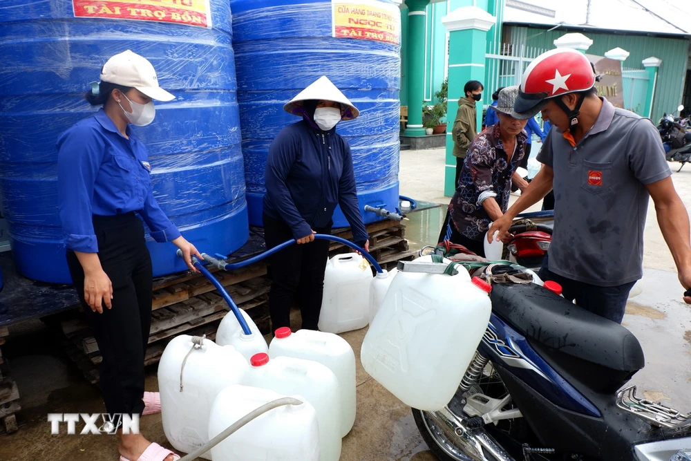 Thanh niên và dân quân là lực lượng túc trực thường xuyên hỗ trợ cấp nước cho người dân vùng hạ huyện Cần Giuộc, tỉnh Long An. (Ảnh: Đức Hạnh/TTXVN)