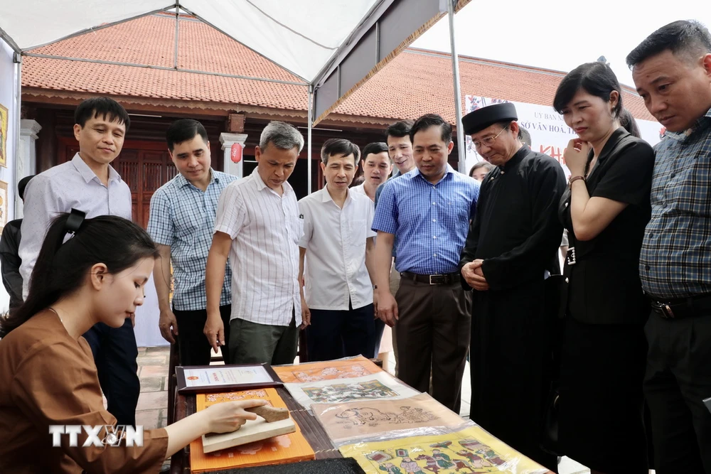 Các đại biểu tham quan một gian hàng tại Không gian trưng bày tái hiện Chợ tranh Đông Hồ. (Ảnh: Đỗ Huyền/ TTXVN)