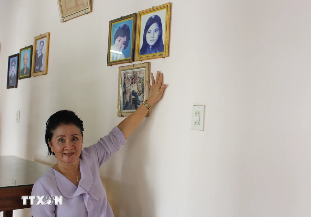 Bà Nguyễn Thị Ngọc Bích kể chuyện về sự kiện gia đình bà may 2 lá cờ giải phóng trước những năm 1975 và hình ảnh của chị gái-liệt sỹ Nguyễn Thị Ngọc Oanh. (Ảnh: Phan Sáu/ TTXVN)