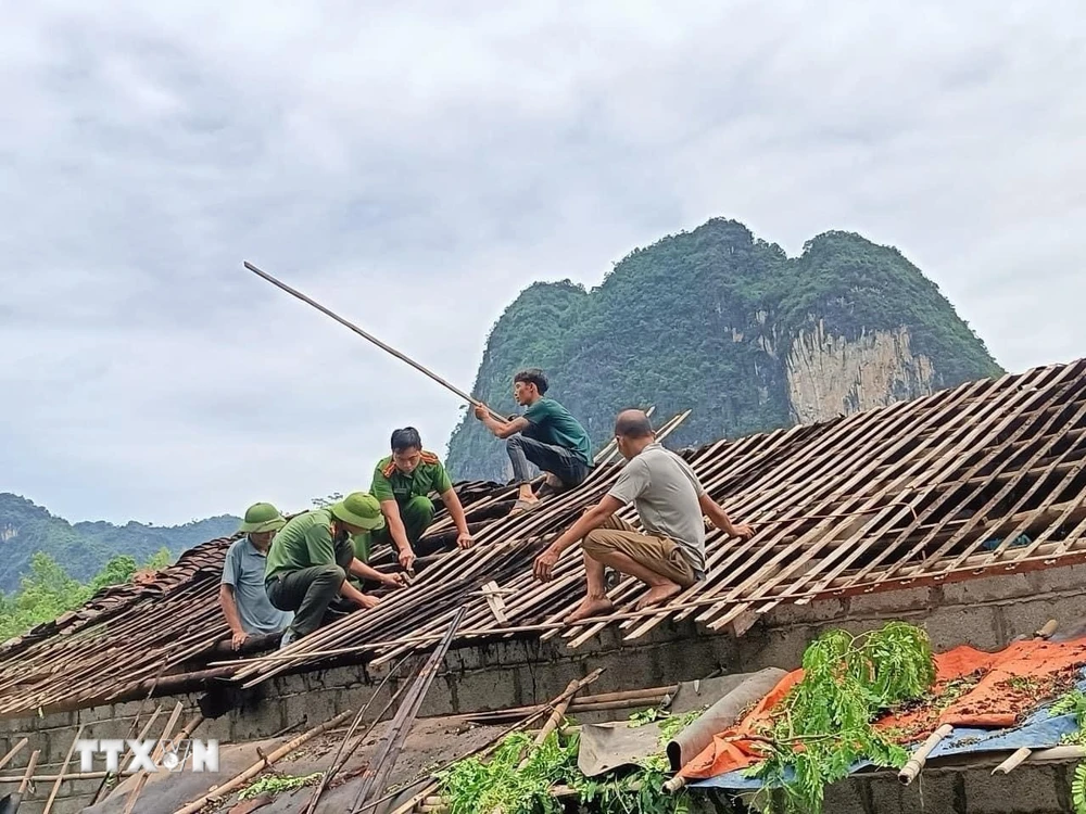 Lực lượng chức năng huyện Hạ Lang, tỉnh Cao Bằng giúp người dân khắc hậu quả của dông lốc. (Ảnh: TTXVN phát)