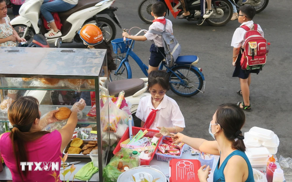 Thực phẩm bán trước cổng trường luôn tấp nập học sinh. (Ảnh: Đinh Hằng/TTXVN)