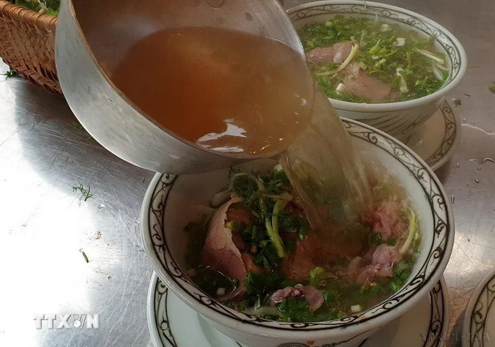 Nước dùng của phở phải trong, nóng, chan vào bát phải đủ để làm dậy lên hương vị của bánh phở, rau thơm, hành và thịt. (Ảnh: Ngọc Liên/TTXVN)