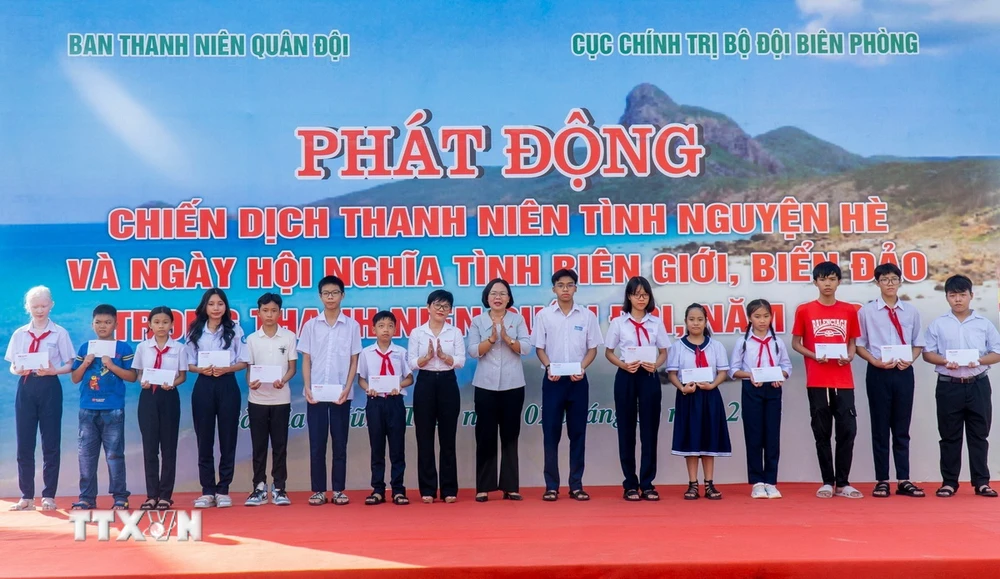 Các đại biểu tặng quà cho các cháu học sinh có hoàn cảnh khó khăn vượt khó, học giỏi. (Ảnh: Huỳnh Sơn/TTXVN)