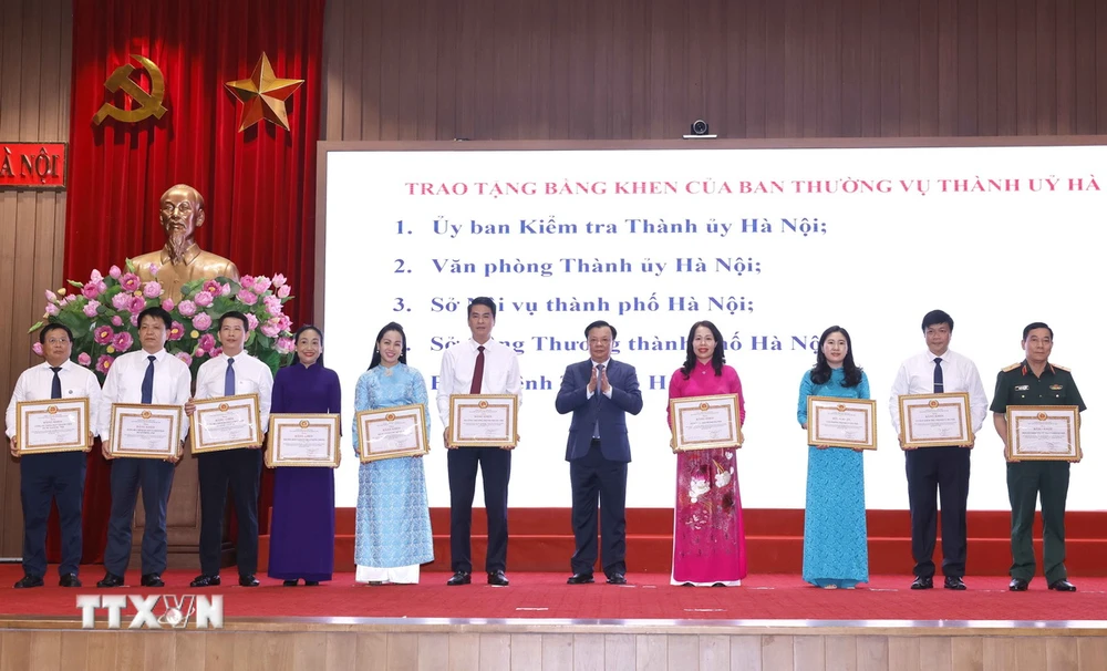 Bí thư Thành ủy Hà Nội Đinh Tiến Dũng trao tặng Bằng khen của Ban Thường vụ Thành uỷ cho các đơn vị có thành tích xuất sắc. (Ảnh: Doãn Tấn/TTXVN)