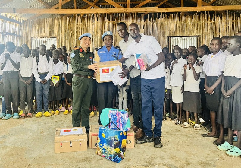 Trung tá Bùi Phương Lân thay mặt Tổ công tác Bộ Công an tại phái bộ UNMISS trao quà cho các em học sinh tại Trường Tiểu học Thống nhất, Nam Sudan. (Nguồn: Bộ Công an)