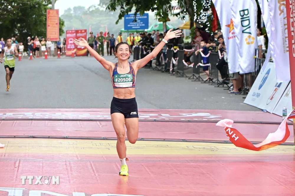 "Cô gái vàng” điền kinh Việt Nam Nguyễn Thị Oanh cán đích đầu tiên ở nội dung cự ly 21km dành cho nữ. (Ảnh: Nguyên Linh/TTXVN)