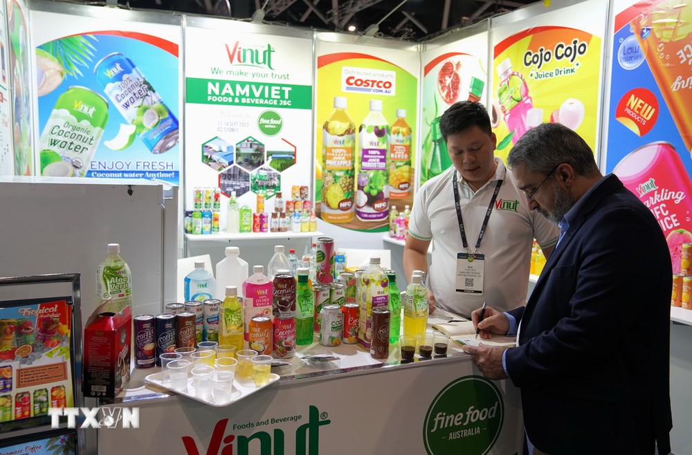 Khách tham quan tìm hiểu về thông tin các doanh nghiệp đồ uống Việt Nam tại một hội chợ. (Nguồn: TTXVN)