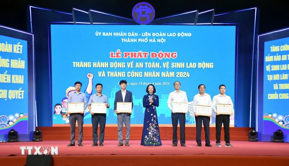 Phó Chủ tịch Ủy ban Nhân dân thành phố Hà Nội Vũ Thu Hà trao khen thưởng cho tập thể, cá nhân có thành tích trong công tác an toàn vệ sinh lao động. (Ảnh: TTXVN phát)