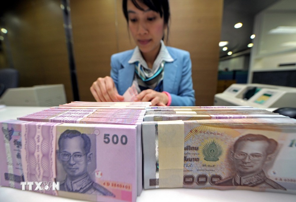 Nhân viên ngân hàng kiểm đếm đồng baht tại Bangkok, Thái Lan. (Ảnh: AFP/TTXVN)
