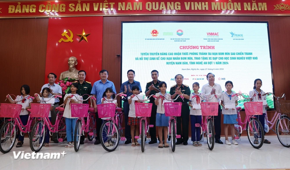 Đoàn công tác trao xe đạp và quà tặng trẻ em có hoàn cảnh khó khăn xã Chiêu Lưu. (Ảnh: Lâm Khánh/Vietnam+)