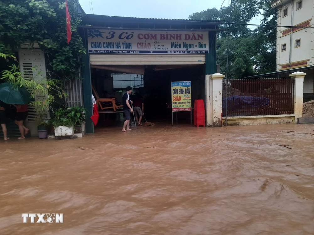 Nhiều nhà dân và các cơ quan đơn vị tại khối 1 thị trấn Mường Xén, huyện Kỳ Sơn (Nghệ An) bị chia cắt do nước lũ chảy xiết. (Ảnh: TTXVN phát)