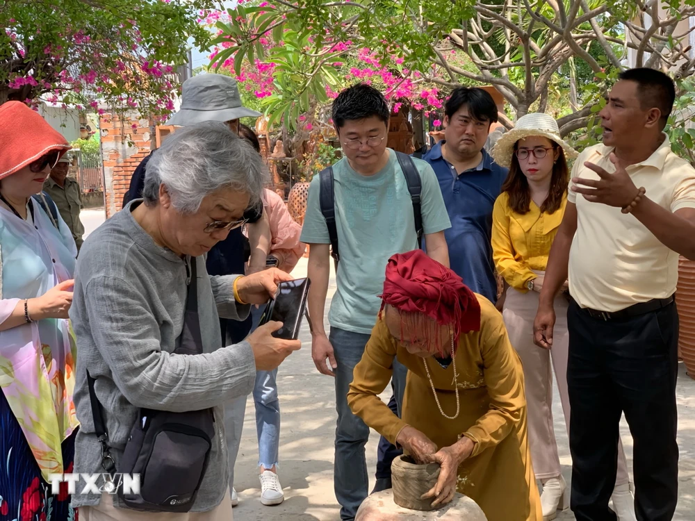 Du khách Hàn Quốc tham quan, tìm hiểu nghệ thuật làm gốm của đồng bào Chăm làng Bàu Trúc ở thị trấn Phước Dân (huyện Ninh Phước). (Ảnh: TTXVN phát)