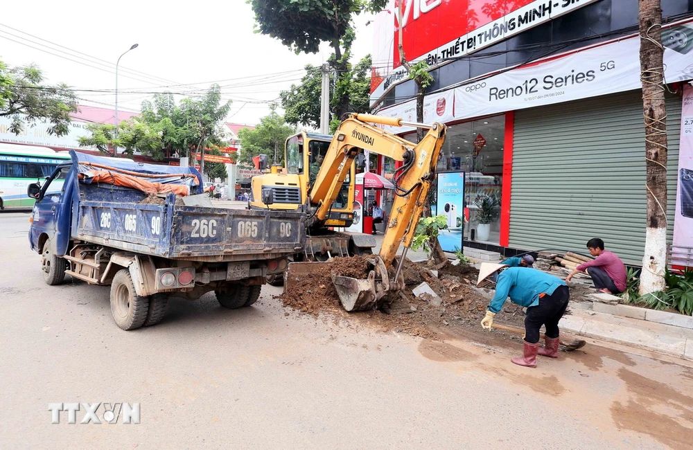 Thành phố Sơn La đã huy động nhân lực, phương tiện máy móc, nạo vét bùn đất, khơi thông đường cống phòng, chống ngập lụt, sáng 28/7. (Ảnh: Quang Quyết/- TTXVN)