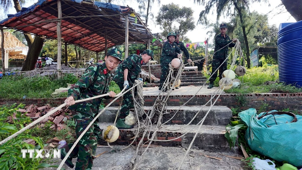 Lực lượng Biên phòng Cô Tô giúp người dân chằng chống tàu thuyền tại nơi neo đậu an toàn. (Ảnh: TTXVN phát)