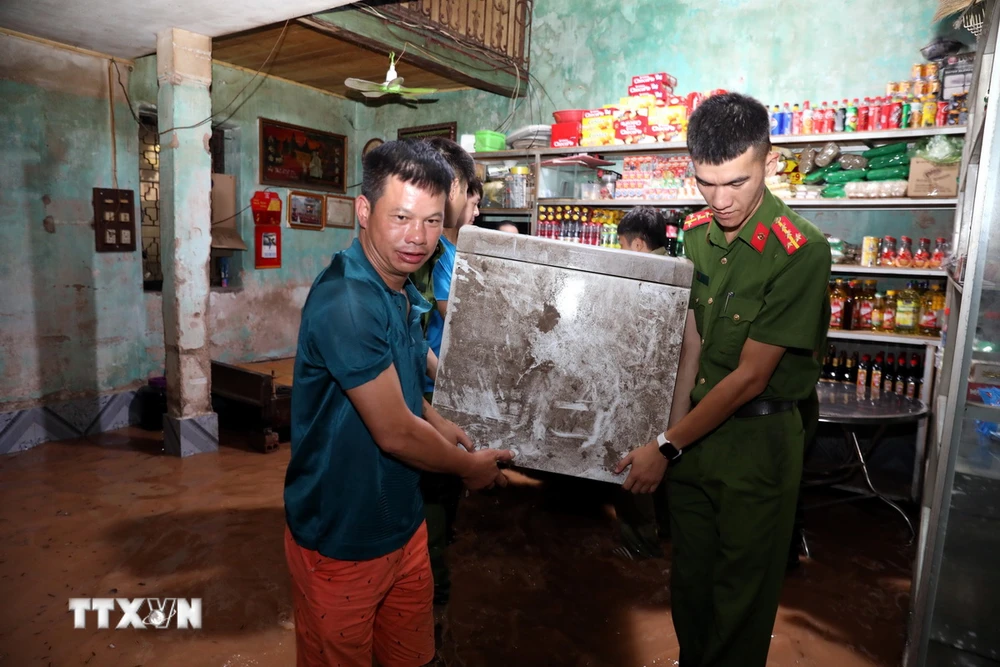 Lực lượng chức năng thành phố Lạng Sơn hỗ trợ gia đình bà Nguyễn Thị Hoa ở khu vực khối Cửa Bắc, phường Chi Lăng, thành phố Lạng Sơn di chuyển đồ đạc đến nơi an toàn. (Ảnh: Văn Đạt/TTXVN)