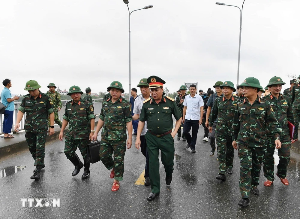 Trung tướng Phạm Đức Duyên, Bí thư Đảng ủy, Chính ủy Quân khu 2 và đại diện các đơn vị khảo sát vị trí lắp cầu phao. (Ảnh: TTXVN phát)