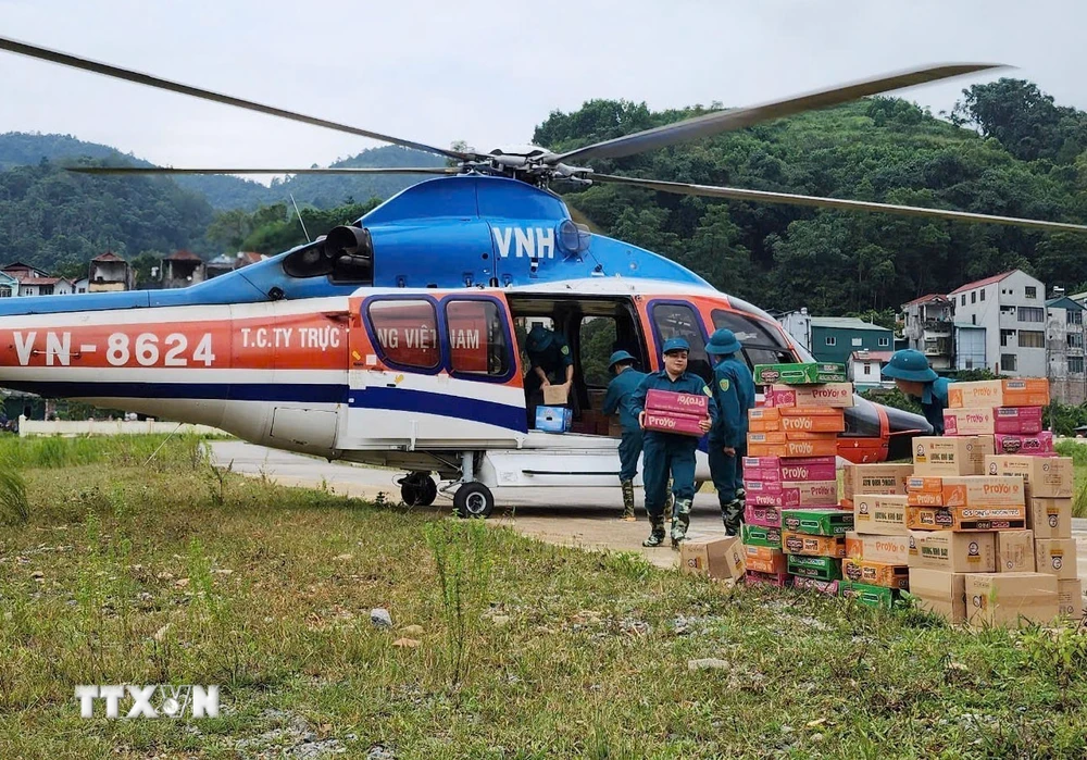 Chuyển hàng cứu trợ từ trực thăng xuống vùng lũ thuộc huyện Nguyên Bình. (Ảnh: Thông tấn Quân sự/TTXVN phát)