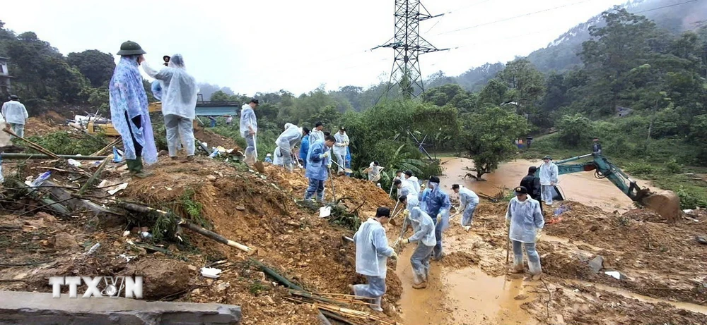 Cán bộ, chiến sỹ Công an tỉnh Hà Giang và các lực lượng chức năng nỗ lực tìm kiếm nạn nhân mất tích trong vụ sạt lở nghiêm trọng. (Ảnh: TTXVN phát)