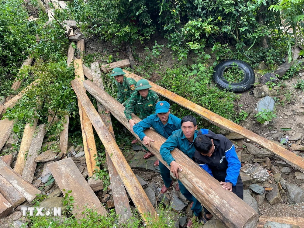 Chính quyền địa phương huy động lực lượng đưa người và tài sản của người dân vùng nguy cơ sạt lở đến nơi an toàn. (Ảnh: TTXVN phát)