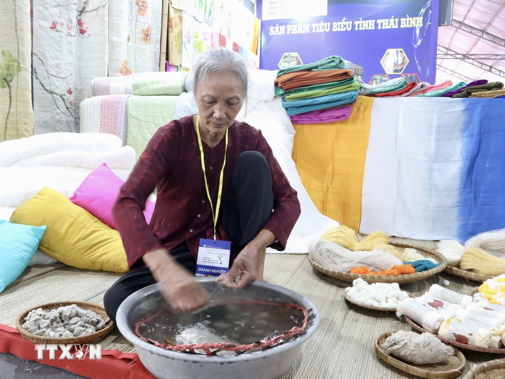 Nghệ nhân làng nghề lụa, đũi Nam Cao (Thái Bình) tái hiện hoạt động se sợi. (Ảnh: Xuân Anh/TTXVN)